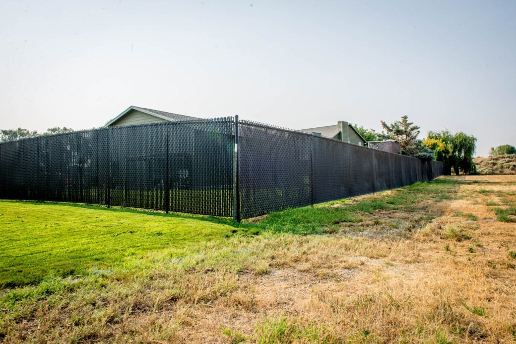 1033 Chain Link Fencing Chain link fence with black privacy slats.