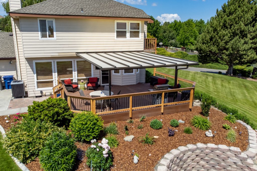 Richland deck and cover 28 A house with a covered deck and landscaped yard