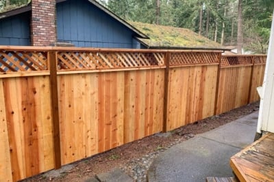 1024 Fencing Cedar Lattice Top A cedar lattice top fence in front of a blue house.