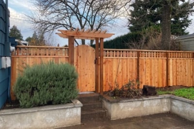 1033 Fencing Cedar Lattice Top A cedar lattice top fence with a gate and pergola.