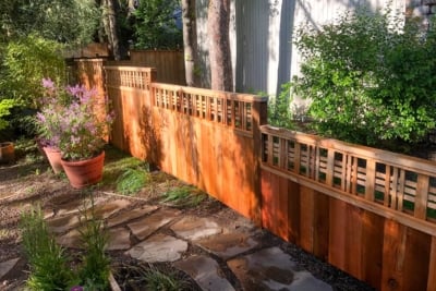 1035 Fencing Cedar Lattice Top A Catalina lattice top fence next to potted plants and a stone path.