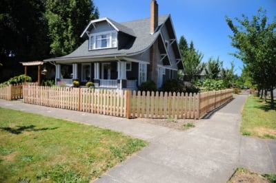 1003 Fencing Cedar Picket A wooden picket fence surrounding a front yard.