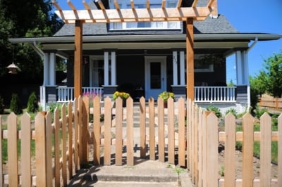 1005 Fencing Cedar Picket A cedar picket fence with with a gate.
