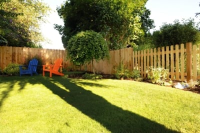 1009 Fencing Cedar Picket A picket fence meeting up with another cedar fence.