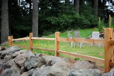 1010 Cedar Split Rail Fencing A cedar split rail fence with patio furniture in the background.