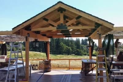 1096 Covers Wood Framed A freestanding wooden gable patio cover surrounded by ladders.
